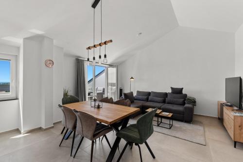 a dining room and living room with a table and chairs at Penthouse Stella Marini with jacuzzi and sea view 2,5 km from sea in Tar
