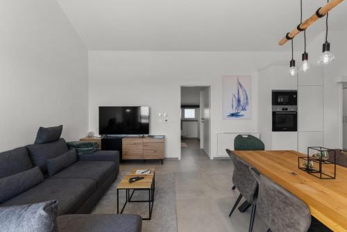 a living room with a couch and a table at Penthouse Stella Marini with jacuzzi and sea view 2,5 km from sea in Tar