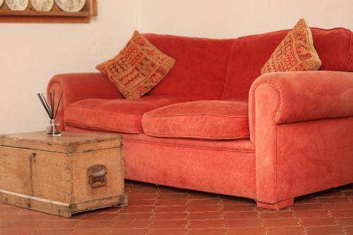 a red couch with pillows and a wooden box at Pure Gardères in Monlezun