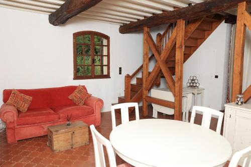 a living room with a red couch and a table at Pure Gardères in Monlezun