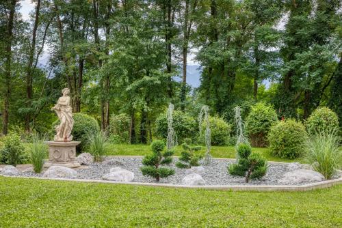 a statue of a woman in a garden at Vitalhotel Marienhof in Velden am Wörthersee