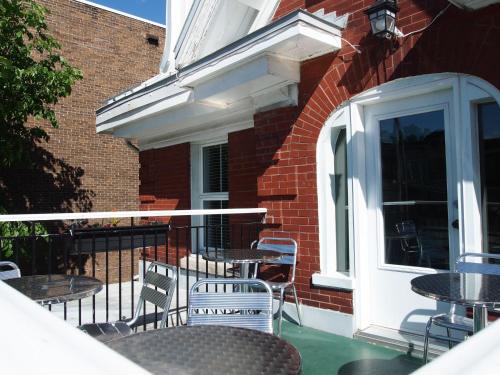 an outdoor patio with tables and chairs and a window at Auberge aux Deux Lions in Quebec City