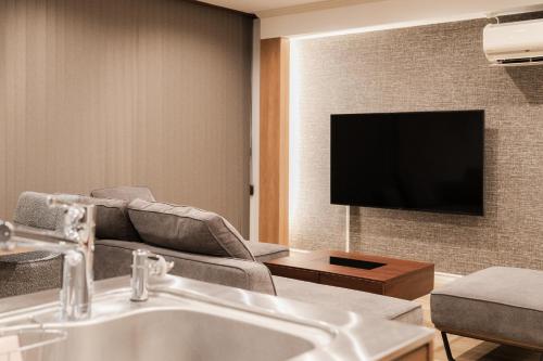 a living room with a couch and a television at The LOFT INN FUKUOKA in Fukuoka