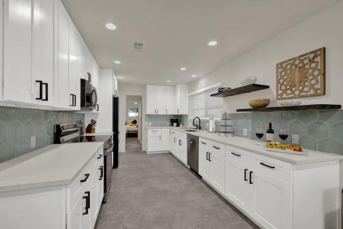 a kitchen with white cabinets and white counter tops at Whitewater River House - Game Room, Firepit, Walking distance to Whitewater Amphitheater! in Sattler