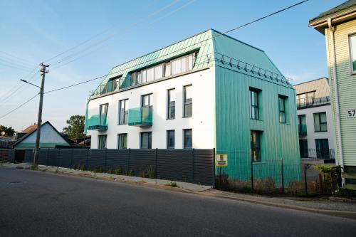 a green and white building on the side of a street at Sodų Vilos in Kaunas