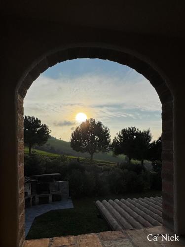 a view of the sunset through a stone archway at Farm Ca Nick in Fermo