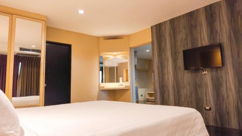a bedroom with a bed and a tv on a wall at Avana Bangkok Hotel & Convention Centre in Bangna