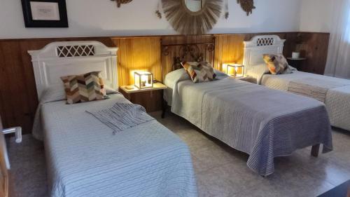 a hotel room with two beds and two lamps at Mary's Home in Moya