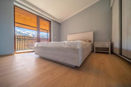 a bedroom with a bed and a large window at Bakurian inni in Bakuriani