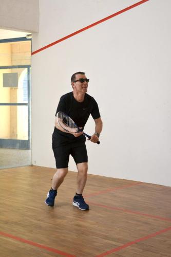 a man holding a tennis racket in a gym at Malibu Village in Canet-en-Roussillon