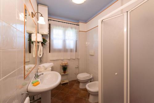ein weißes Badezimmer mit Toilette und Waschbecken in der Unterkunft Casa Lari in San Gimignano