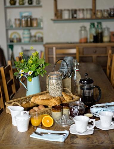 a wooden table with bread and jars of food on it at Pure Gardères in Monlezun