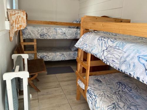 ein Zimmer mit zwei Etagenbetten und einem Schreibtisch in der Unterkunft Tokkelos - Beach front Bungalow in Witsand
