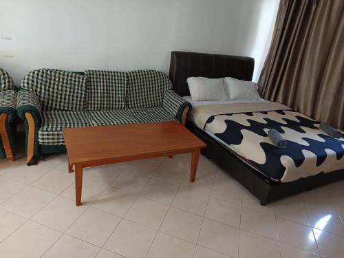 a living room with a couch and a coffee table at My Getaway Home @Marina Cove in Lumut