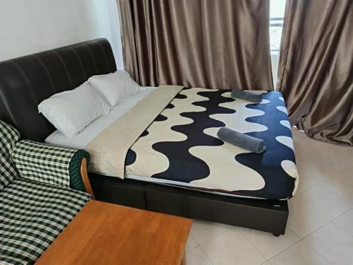a bed in a room with a camouflage blanket and a couch at My Getaway Home @Marina Cove in Lumut