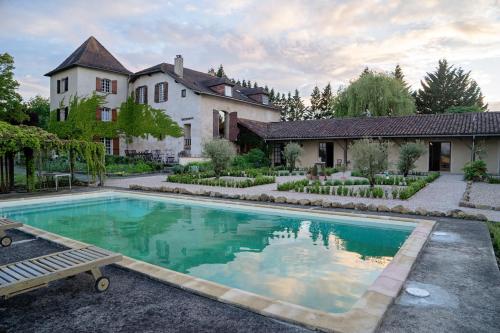 a house with a swimming pool in front of a house at Pure Gardères in Monlezun