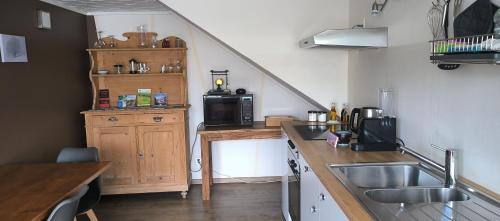 a kitchen with a sink and a counter with a microwave at Mini Happy home in Reconvilier