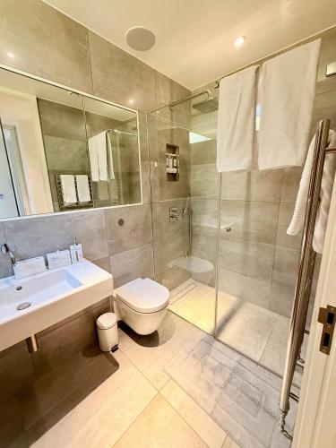 a bathroom with a shower and a toilet and a sink at Central London Designer Home w Game Room and AC in London