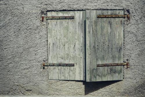 a pair of wooden doors on the side of a building at Pure Gardères in Monlezun
