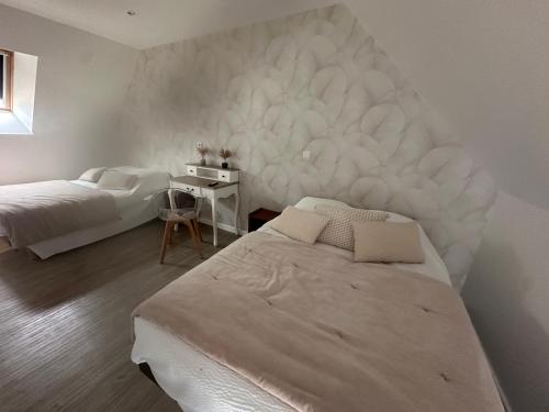 a bedroom with two beds and a white wall at Les gîtes de Joséphine proche Chambord in Courbouzon