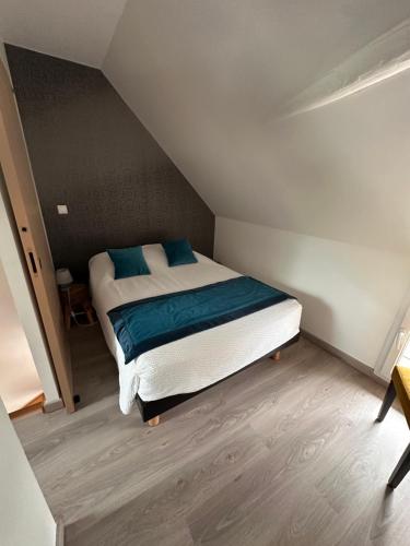 a bedroom with a bed with blue pillows on it at Les gîtes de Joséphine proche Chambord in Courbouzon