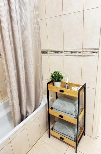 a bathroom with a bathtub and a table with towels at Stay in Harmony in Paralimni