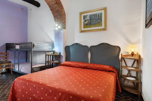 a bedroom with a bed with a red comforter at VECCHIO MULINO FONTONA Ortensia in Chiesanuova