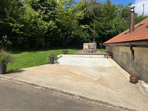 a patio with a bench and a table in a yard at La Borbiatte in Montavon