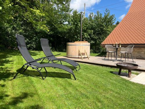 two chairs and a table in a yard with grass at La Borbiatte in Montavon