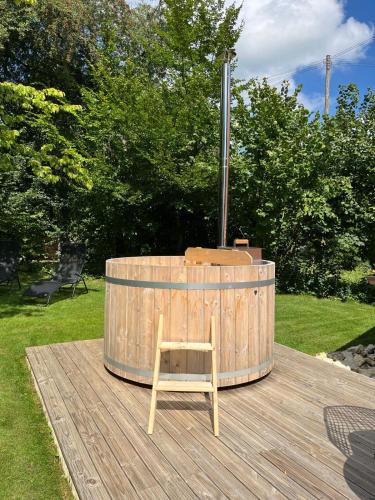 a wooden barrel with a chair sitting on a wooden deck at La Borbiatte in Montavon