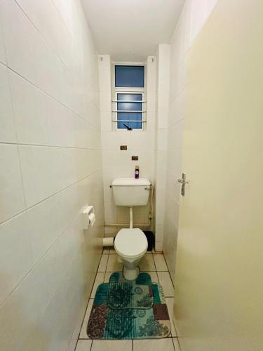a small bathroom with a toilet and a window at Coastal Bliss Retreat Peacehaven 207 in Scottburgh