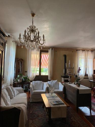 a living room with couches and a chandelier at B&B Dora e Flavio Country Rooms in Montegrotto Terme