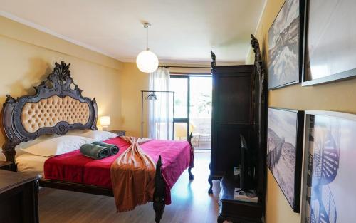 Un dormitorio con una cama grande con una manta roja. en Apartamento T3 perto do Centro do Porto, Check-in 24 horas,Cozinha totalmente equipada, Wi-Fi 44Mbps, Propriedade Confortável e Espaçosa, Com Vaga de Carro Pública, Adequada para famílias, hóspedes em negócios e grupos de amigos e nomades digitais, en Oporto