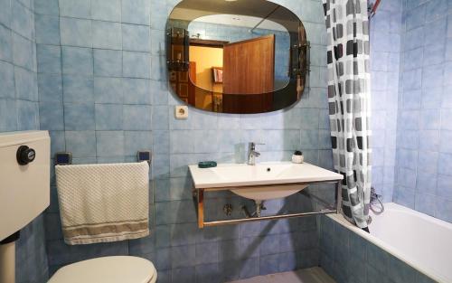 Un baño con lavabo, inodoro y espejo. en Apartamento T3 perto do Centro do Porto, Check-in 24 horas,Cozinha totalmente equipada, Wi-Fi 44Mbps, Propriedade Confortável e Espaçosa, Com Vaga de Carro Pública, Adequada para famílias, hóspedes em negócios e grupos de amigos e nomades digitais, en Oporto