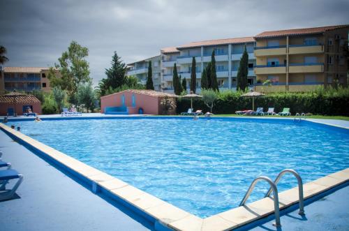 a large swimming pool in front of a building at Malibu Village in Canet-en-Roussillon