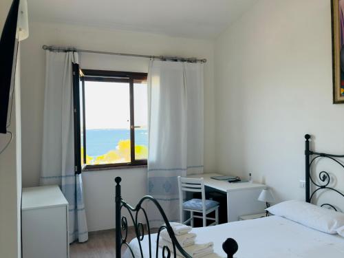 a bedroom with a bed and a desk and a window at Blumarine in Palau