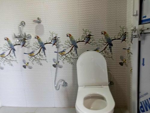a bathroom with birds on the wall next to a toilet at Peace Home Homestay in Nagarkot