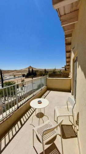 a patio with a table and chairs on a balcony at ליד המצוק in Mitzpe Ramon