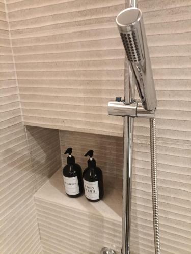 a bathroom with two soap dispensers on a shelf at El balconcito al mar in Nerja