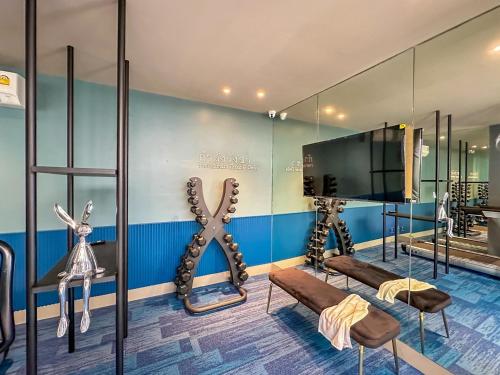 a room with a tv and a large mirror at ARNI HER Ladies Hotel - Female Only in Bangkok