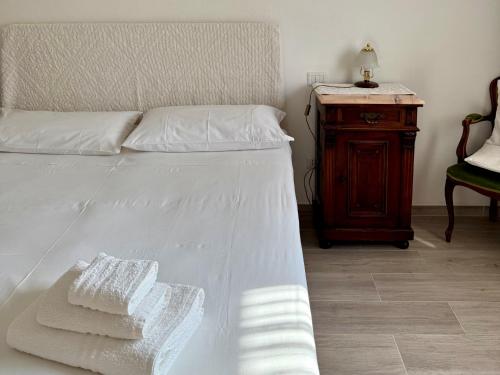 a bedroom with a bed with white sheets and a wooden table at Blumarine in Palau