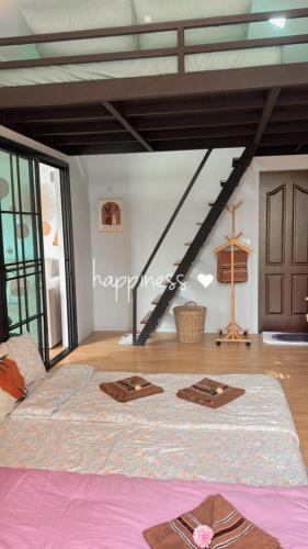 a bedroom with a large bed and a staircase at Cana Garden House 1 โฮมสเตย์ in Ban Khok