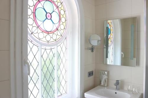 a bathroom with a sink and a stained glass window at Hotel Villa WellenRausch in Travemünde