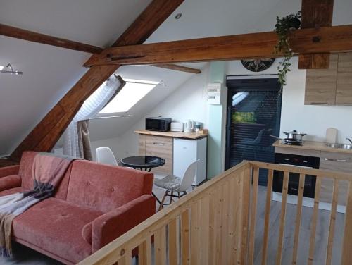 a living room with a red couch and a kitchen at Cozy Loft in Hazebrouck