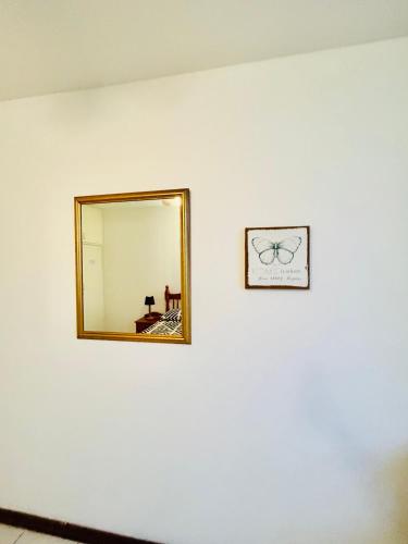 a mirror on a white wall with a picture at Coastal Bliss Retreat Peacehaven 207 in Scottburgh