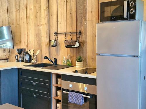 a kitchen with a refrigerator and a sink at Joli Appartement cosy in Guny