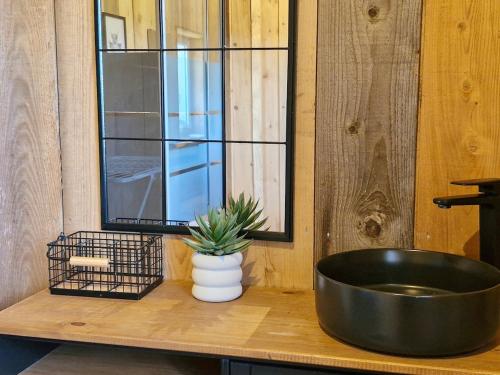 a black tub sitting on a wooden counter with a plant at Joli Appartement cosy in Guny