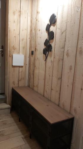 a room with a wooden wall with a bench at Joli Appartement cosy in Guny