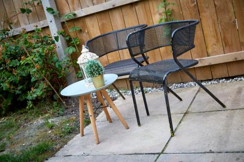 two chairs and a table next to a fence at Stylish and cosy home-from-home in Hessle
