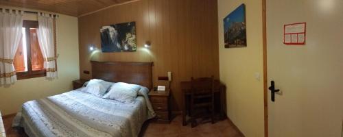 a bedroom with a bed and a table in it at Hotel Sarao in Escarrilla